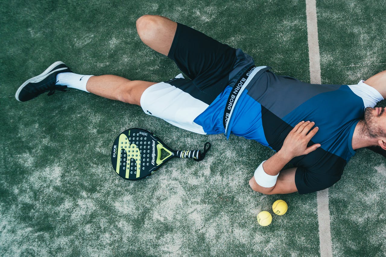 The Art of Drawing Readers In: Your attractive post title goes here Tired young athlete resting on padel court with racket and balls nearby.